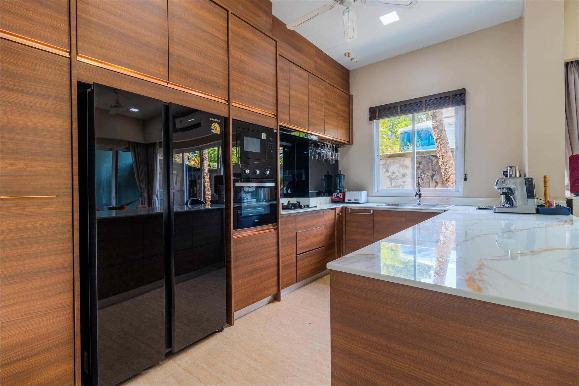 Fully equipped professional kitchen with modern appliances and island counter at the luxury villa