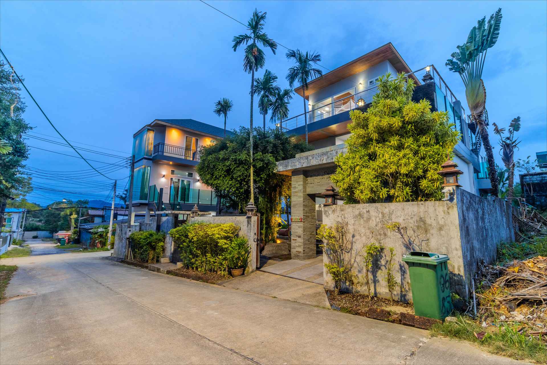 Side view of the Phuket luxury villa showcasing modern Thai architecture and palm trees